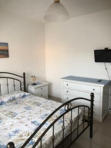 a bedroom with a bed and a dresser at Blue Apartment in La Maddalena