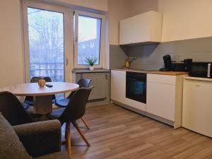 - une cuisine avec une table, des chaises et une table dans l'établissement THEOX No 3 in Duisburg, à Duisbourg