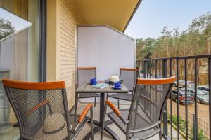 patio ze stołem i krzesłami na balkonie w obiekcie Elegant Apartment Na Wydmach with Balcony and Parking by Renters w mieście Międzywodzie