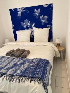 ein Schlafzimmer mit einem Bett mit blauen Blumen darauf in der Unterkunft Calme et tranquillité -Ile de Ré in Rivedoux-Plage