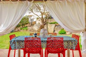 a table with red chairs and a blue table cloth at Villa Quattro Cuori in San Teodoro