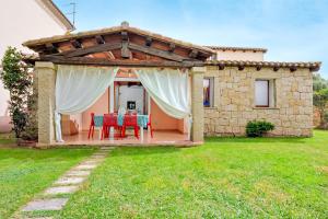 a patio with a table and chairs under a pergola at Villa Quattro Cuori in San Teodoro