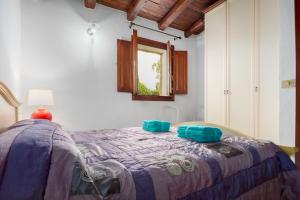 a bedroom with a bed with blue pillows on it at Villa Quattro Cuori in San Teodoro