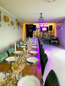ein langer Tisch mit Tellern und Gläsern darauf in der Unterkunft Casa Mina Divici in Divici