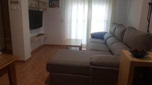 sala de estar con sofá y TV en Apartamentos La Atalaya 188 - 189, en Conil de la Frontera