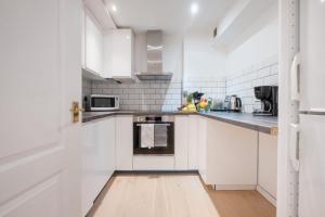 eine weiße Küche mit weißen Schränken und Geräten in der Unterkunft London Fitzrovia CityApartmentStay in London