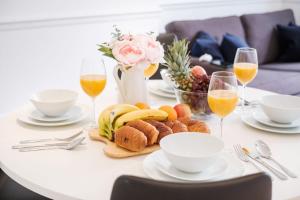 a table with a plate of food and glasses of wine at London Fitzrovia CityApartmentStay in London