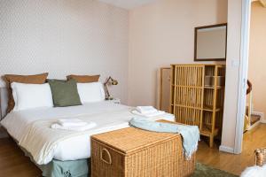 a bedroom with a large bed with a wicker trunk at Impar Triplex House in Porto