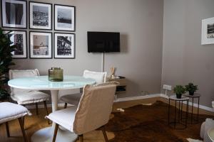 a living room with a table and chairs and a tv at Impar Triplex House in Porto