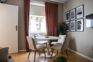 una sala da pranzo con tavolo, sedie e finestra di Impar Triplex House a Porto