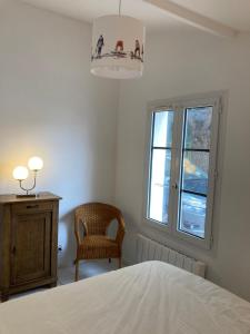 1 dormitorio con 1 cama, 1 silla y 1 ventana en Calme et tranquillité -Ile de Ré, en Rivedoux-Plage
