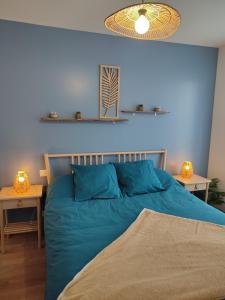 ein blaues Schlafzimmer mit einem Bett und zwei Tischen in der Unterkunft La Rose Paisible in Brusson