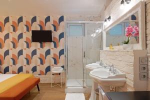 a bathroom with two sinks and a tv on the wall at Cosy and modern updated studio in Paris