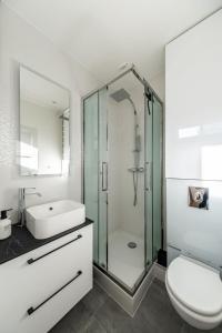 La salle de bains est pourvue d'une douche, de toilettes et d'un lavabo. dans l'établissement Appartement Prestige Champs Elysées, à Suresnes