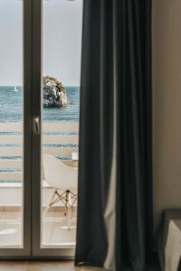 a room with a view of the ocean through a window at Bianco Resort in Parga