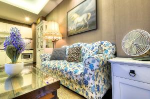 a living room with a blue and white couch and a fan at The Title Boutique Phuket in Rawai Beach