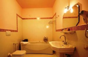 La salle de bains est pourvue d'une baignoire, de toilettes et d'un lavabo. dans l'établissement Palace Hotel Una Nuova Strada, à Nocera Terinese