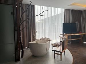 a bathroom with a bath tub next to a window at Minawa Kenhga Resort & Spa Ninh Binh in Ninh Binh