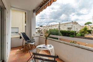 balcón con 2 sillas, mesa y ventana en Canela Homes COSTA CASA AILA, en Castelldefels