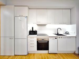 a kitchen with white cabinets and a refrigerator at Moderno apartamento tipo loft en Terrassa centro in Terrassa
