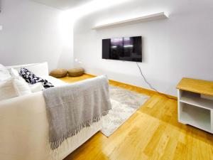 a living room with a white couch and a tv at Moderno apartamento tipo loft en Terrassa centro in Terrassa