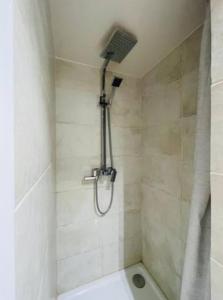 y baño con ducha con cabezal de ducha. en Centre Ahimsa, en Verrières-le-Buisson