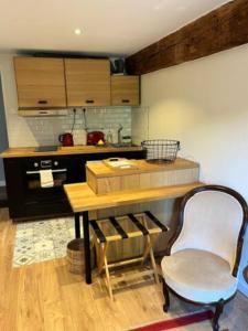 a kitchen with a table and a chair in a room at Centre Ahimsa in Verrières-le-Buisson