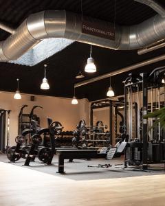 a gym with lots of equipment and pendant lights at Bernstein Salzlandcenter in Staßfurt
