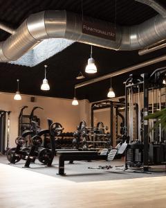 einen Fitnessraum mit vielen Geräten und Hängelampen in der Unterkunft Bernstein Salzlandcenter in Staßfurt