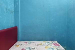 a bed in a room with a blue wall at OYO 93875 Tifar House in Pallenguk