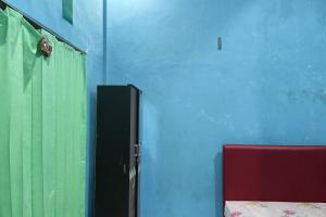 a room with a blue wall and a door at OYO 93875 Tifar House in Pallenguk