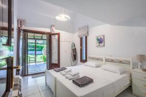 a bedroom with a white bed with towels on it at Luxurious Sani Villa Luna with shared pool in Sani Beach +36 photos