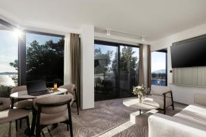 a living room with a couch and a tv at SeeSea Hotel in Vodice