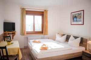 Schlafzimmer mit einem Bett, einem Tisch und einem Fenster in der Unterkunft Gasthof Blankenberg 