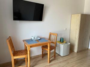 einen Tisch und zwei Stühle sowie einen TV an der Wand in der Unterkunft Willa Kinga in Władysławowo
