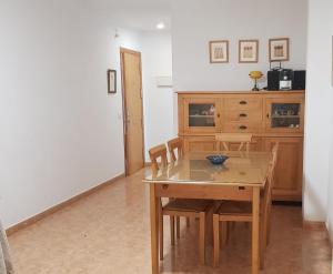 a dining room with a table and chairs and a cabinet at Apartamentos La Atalaya 188 - 189 in Conil de la Frontera