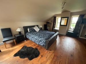 1 dormitorio con 1 cama, 1 silla y 1 alfombra en Riverside converted Linen Mill, en Coleraine