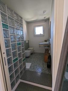 baño con aseo y pared de cristal en Appartamento Ilaria, en Dueville
