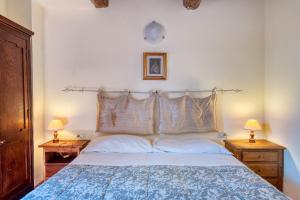 ein Schlafzimmer mit einem großen Bett mit zwei Nachttischen in der Unterkunft Bosco ad Antico Casale '700 in Umbertide