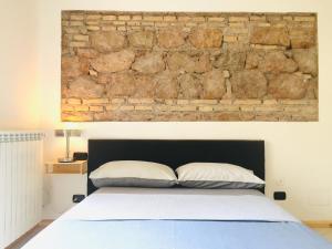 a bedroom with a brick wall above a bed at Art House Center Rome in Rome