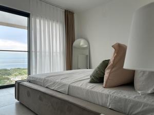 a bedroom with a large bed with a large window at Penthouse i sjøkanten på Dejablue in Kyrenia