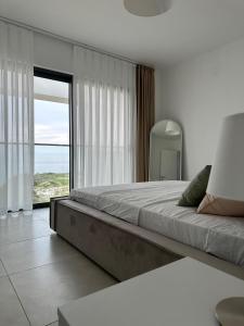 a bedroom with a large bed and a large window at Penthouse i sjøkanten på Dejablue in Kyrenia