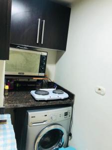 a kitchen with a microwave and a washing machine at شاليه in El Alamein