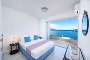 a bedroom with a bed and a view of the ocean at Sea View Bliss 2BR Agios Nikolaos WiFi in Agios Nikolaos