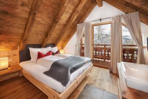 Schlafzimmer mit einem Bett, einem Waschbecken und einer Badewanne in der Unterkunft Chalet "Ostermoasspitz" - es erwarten Sie traditionelle Gemütlichkeit kombiniert mit modernstem Komfort in Sankt Martin am Tennengebirge