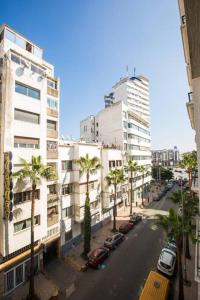 una calle de la ciudad con palmeras y edificios altos en Lovely studio in the center of Casablanca en Casablanca