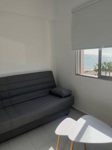Habitación con sofá, 2 sillas y ventana en SEA VIEW APARTMENT / a primera línea de playa, en Málaga