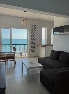 uma sala de estar com um sofá e uma mesa em SEA VIEW APARTMENT / a primera línea de playa em Málaga