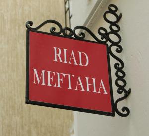 a red sign that reads hadmetritis hanging on a building at Riad Meftaha in Rabat