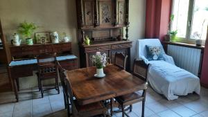 ein Wohnzimmer mit einem Tisch und einem Esszimmer in der Unterkunft Chambres d’Hôtes Les Melogottes in Villapourçon